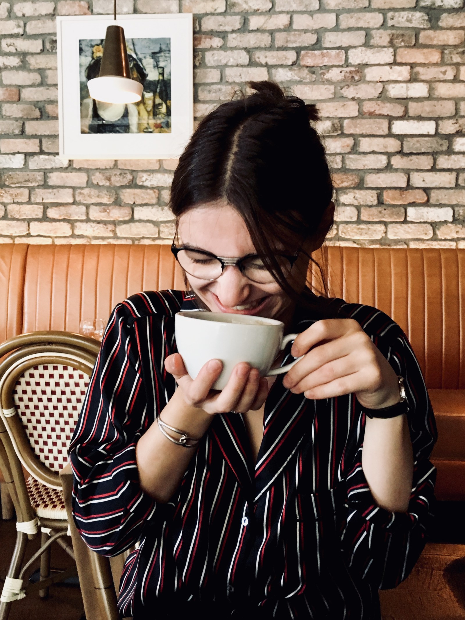 Olive skin French woman drinking coffee in Dublin. 